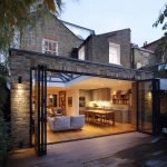 modern house extension with large glass doors. Open plan living area with sofa, dining table, wooden flooring visible through doors. Exterior of brick house. --ar 1:1 --v 7 Job ID: 9009fd41-5a71-4d71-999f-f7a68d05cb20