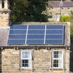 Solar panels fitted to the roof of a traditional stone house 